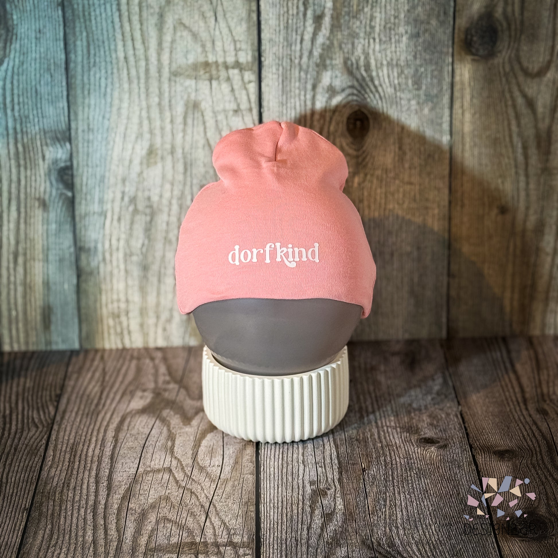 Rosa Babymütze mit Aufdruck „Dorfkind" von Designbär