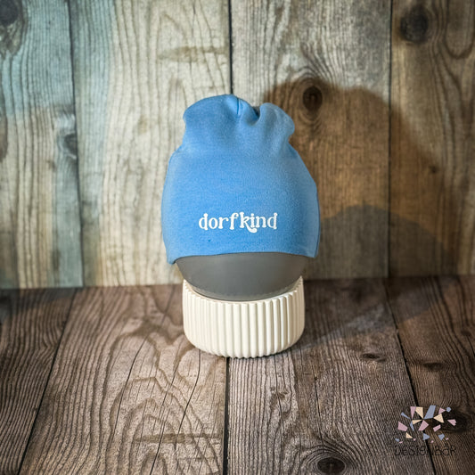 Hellblaue Babymütze mit Aufdruck „Dorfkind" von Designbär