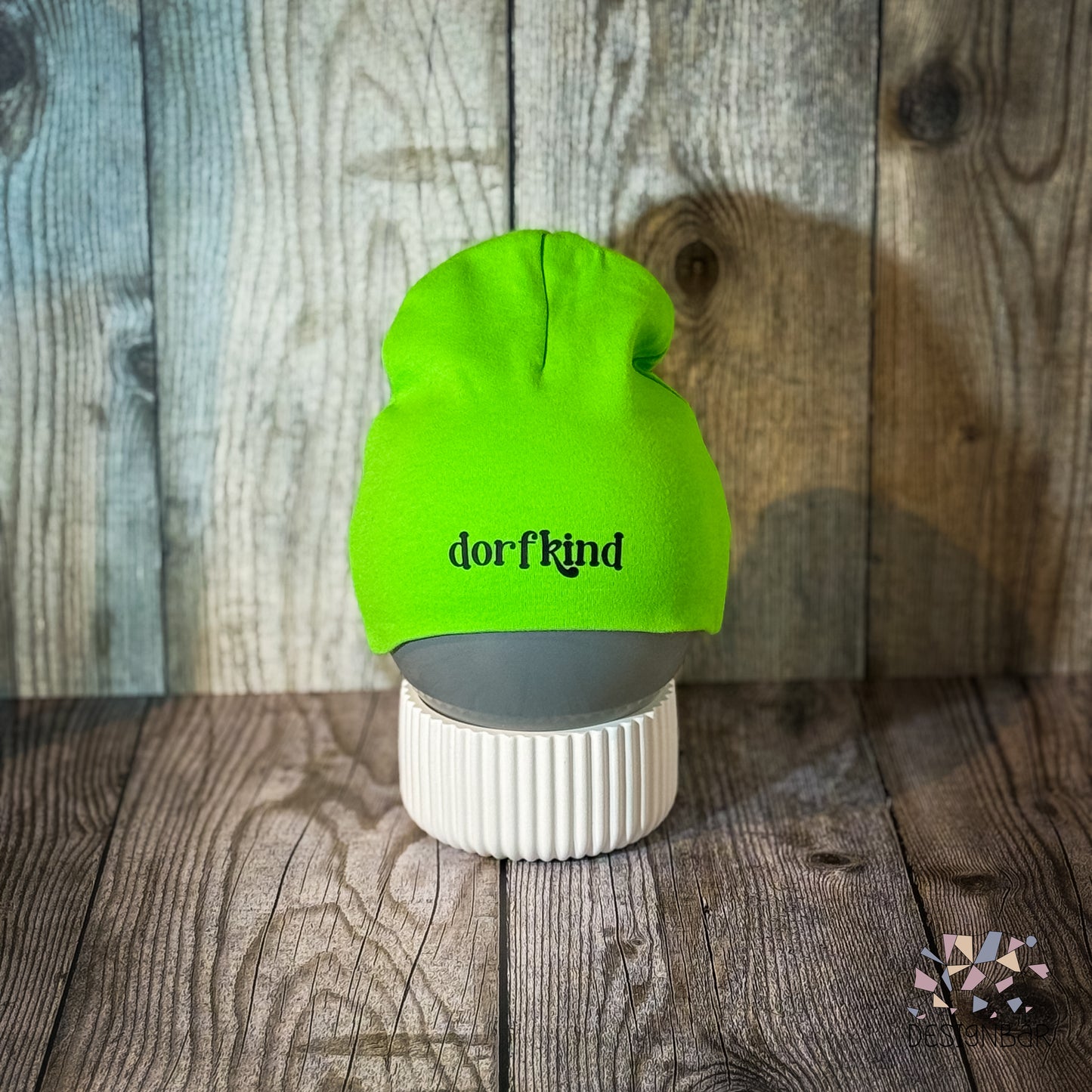 Hellgrüne Babymütze mit Aufdruck „Dorfkind" von Designbär